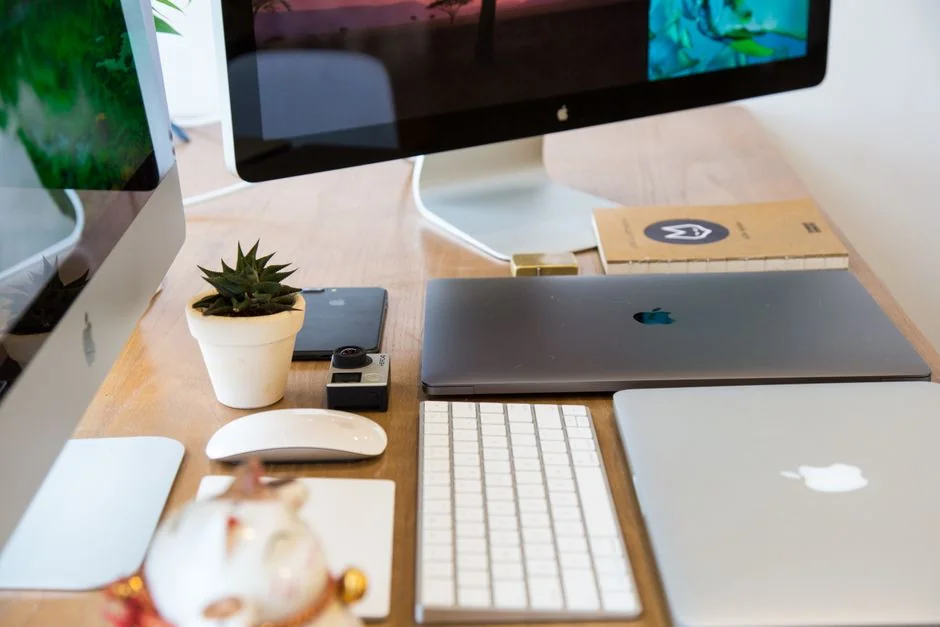 A chic workspace with a laptop and monitors showing design software.